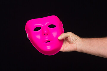 Mask in hand on black background