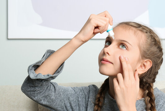 Adorable Little Girl Using Eye Drops Indoors