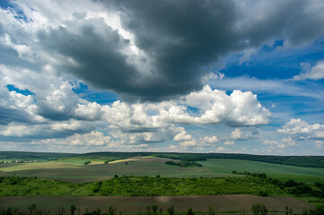 Summer landscape and white clouds over green fields