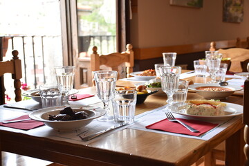 Restaurant table with plates full of food in rural area restaurant. Everything ready to eat and with lots of light coming through the window.