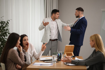 Angry coworkers quarreling at workplace in office
