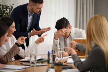 Boss scolding employee at workplace in office