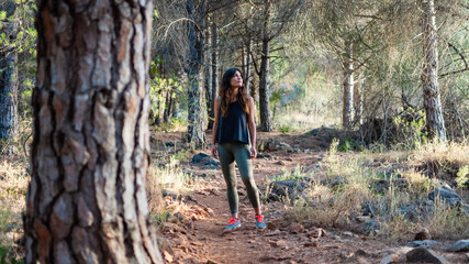 Young woman stands between trees in the country