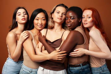 Fototapeta premium young pretty asian, caucasian, afro woman posing cheerful together on brown background, lifestyle diverse nationality people concept
