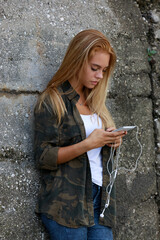 oprofile view of a girl using her smartphone in a suburban stree