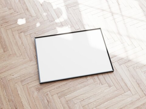High angle view of blank rectangular picture frame laying on wooden parquet flooring. 3D illustration.
