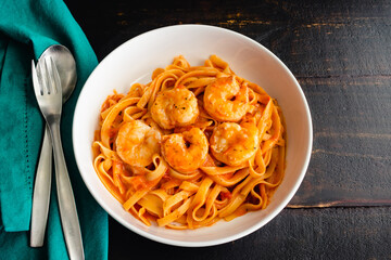 Bowls of Shrimp and Pasta in Tomato Cream Sauce: Bowls of shrimp and fettuccine pasta noodles in a creamy tomato sauce