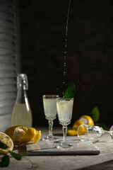Lemoncello in a little glasses and bottle on a black background, Traditional Italian liqueur from...