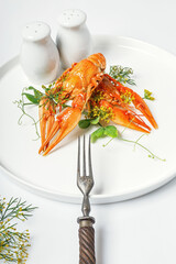 Boiled crayfish with dill and spices on a white plate on a white plate. Delicious crayfish with aromatic dill and spices. Blank for the menu. Organic wild food still life. Food styling. Vertical shot