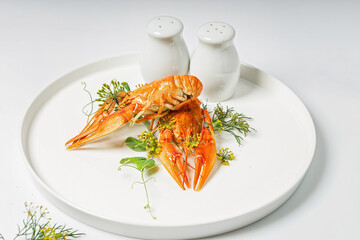 Boiled crayfish with dill and spices on a white plate on a white plate. Delicious crayfish with aromatic dill and spices. Blank for the menu. Organic wild food still life. Food styling. Close-up