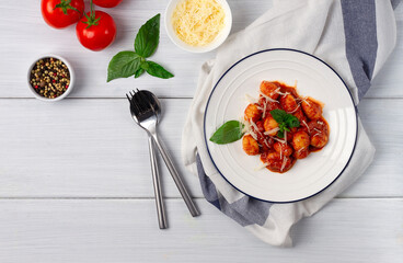 Italian dish, gnocchi with tomato sauce and basil, potato dumplings, on a white wooden table, , no people, top view, 