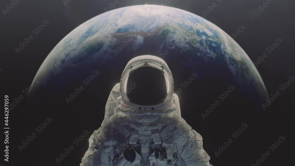 Wall mural dolly in shot of an astronaut with planet earth n the background.