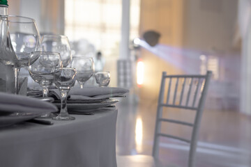 Table and chairs with wine glass, plates full serving. Napkins and cutlery. Low light. Selective focus. Ready to party, celebrate. Restaurant services, public catering enterprises. without food