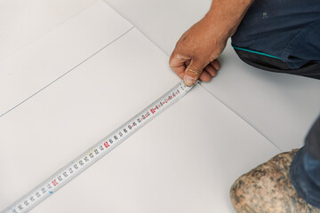 Worker measures with roulette pvc membrane to be cut
