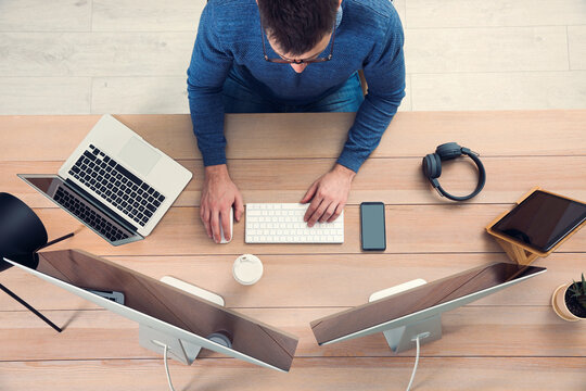 Programmer working at desk in office, top view