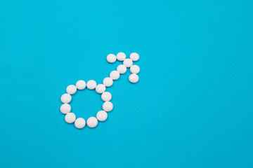 Male Gender Symbol Made from White Pills - Men's Health and Medicine, Medicaments for Men, Lying on Blue Background. Copy Space