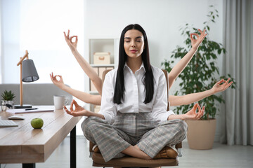 Young woman meditating at workplace. Stress relief exercise - obrazy, fototapety, plakaty