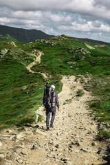 Fototapeta premium young hiker man in mountains. summer trekking path