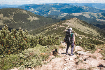 Fototapeta premium young hiker man in mountains. summer trekking path