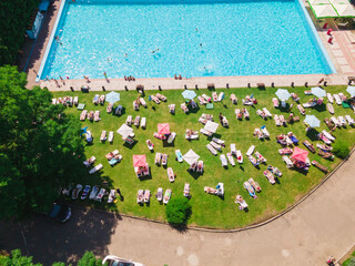 aerial view of people resting sunbathing near city pool