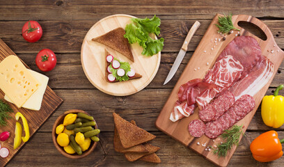 making sandwiches with meat and sausage on wooden table