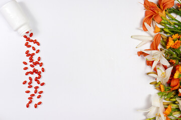 Orange capsules of lutein and medicinal plants on a white background with place for text. Supplements and herbal medicine, homeopathy.