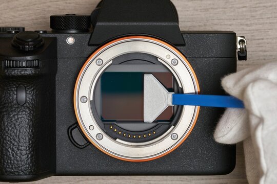 Close-up of Cleaning a modern digital full-frame camera sensor using a sensor swab