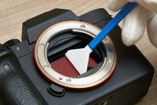 Close-up of Cleaning a modern digital full-frame camera sensor using a sensor swab