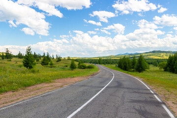 Summer siberian landscape with winding road among green hills in Khakassia, Russia. Russian federal highways