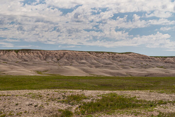 Badlands National Park, SD, USA - June 1, 2008: Beige table ridge with footings on horizon under...