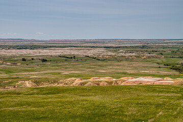 Badlands National Park, SD, USA - June 1, 2008: endless landscape of green prairie with white and...