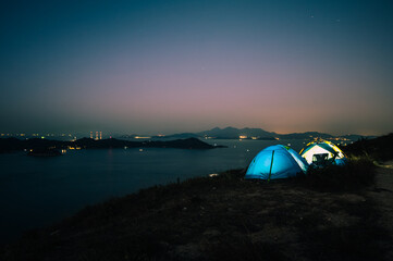 Fototapeta na wymiar Tourist camping tent on top of mountain with sea and sky background, at Yuk Kwai Shan (Mount Johnson) located in Ap Lei Chau,Hong Kong.Traveling and camping concept