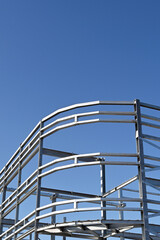 Steel construction frame of a new multi storey commercial building against a blue sky. No people.