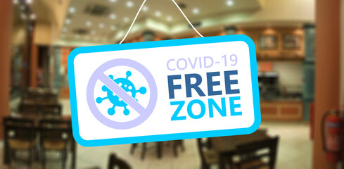 Covid free zone sign. COVID-19 free zone text on a hanging board, cafe restaurant background