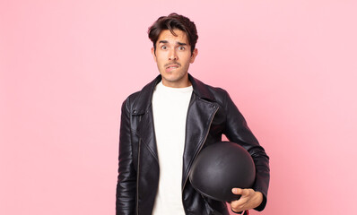 young hispanic man looking puzzled and confused. motorbike rider concept