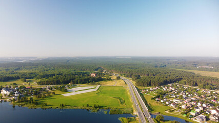 Aerial view of highway road and green meadows and fields