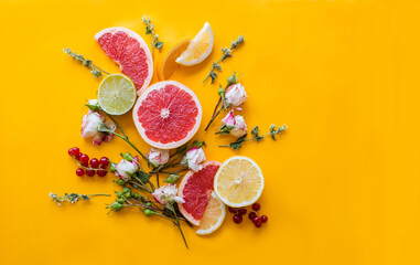 Citrus background with roses. Composition from bright fruits on a yellow background.  Flat lay, copy space.