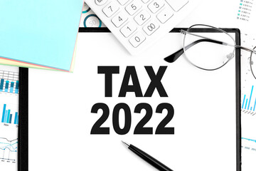 TAX 2022. Clipboard, calculator, chart. Business concept. Flat lay.