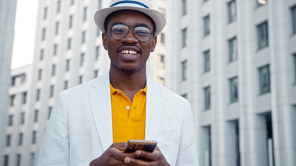 Smiling African American man in glasses and hat looking at camera
