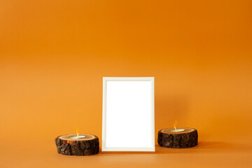 Frame with empty space and candles on orange background