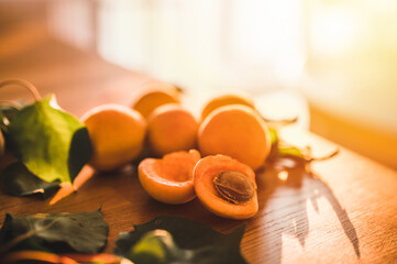 Fresh apricots with green leaves on wood table. Top view. Apricots close up.