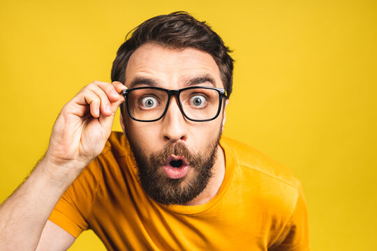 Happy winner! Portrait of shocked amazed young male man keeps mouth widely opened, being surprised, expresses great surprisment. Isolated over pink yellow background.