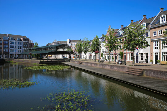 Helmond, Netherlands - July 10. 2021: View over water canal on traditional old dutch houses in summer with blue sky