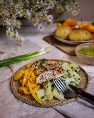 French-style potato salad and chicken cutlets on a light wooden table