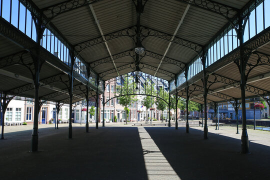 Helmond, Netherlands - July 10. 2021: View on open empty market hall construction, old dutch houses background