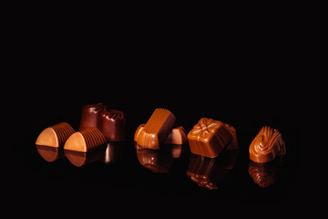 Close up of assorted chocolate sweets on a reflective surface