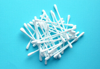 Lots of plastic cotton swabs on a blue background.