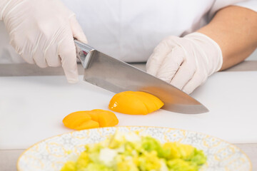 Close up of chef cutting a peach with a kitchen knife