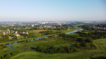 Fototapeta na wymiar Aerial view of the blue river and green meadows
