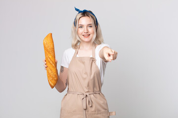 young pretty albino woman pointing at camera choosing you with a bread baguette